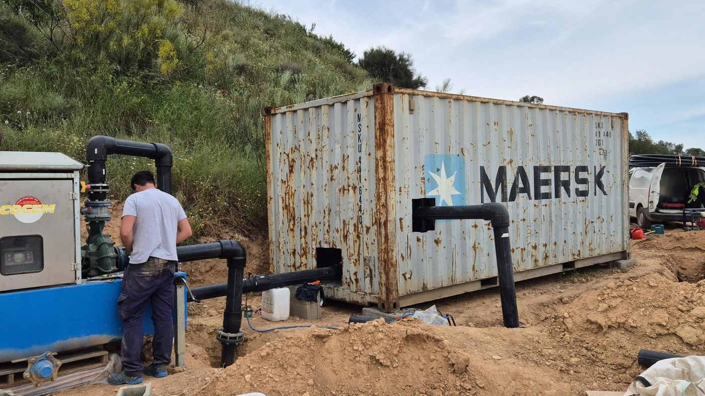 Instalación de grupo de bombeo y tuberías junto a una caseta en el campo