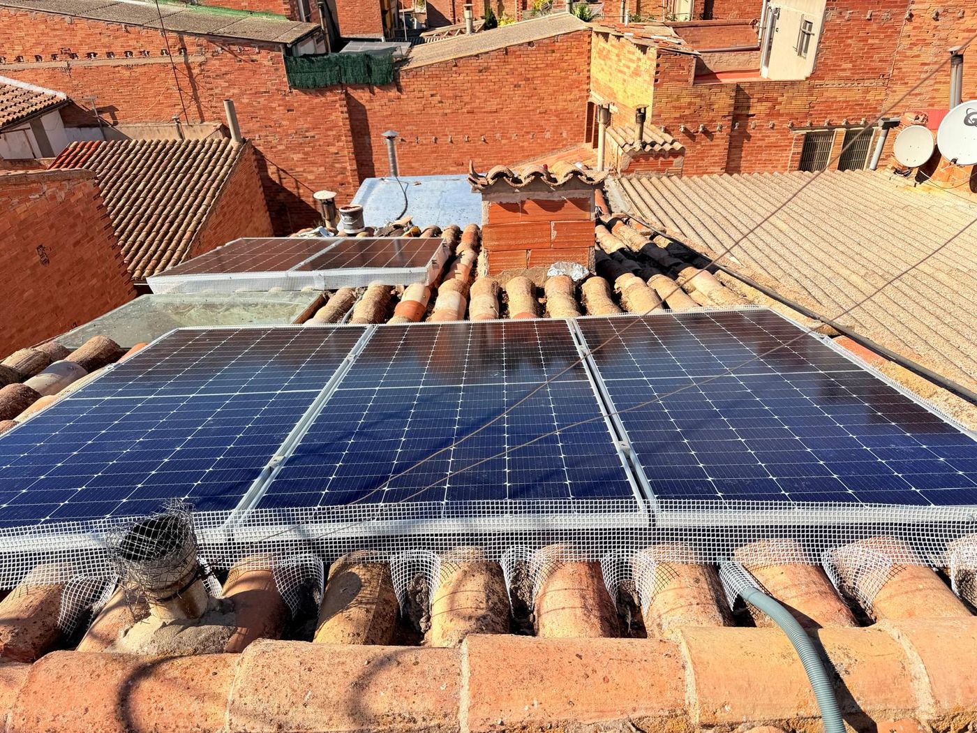 Placas solares instaladas sobre tejado de teja árabe con malla antipájaros