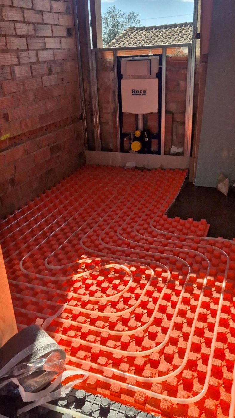 Tubería de suelo radiante sobre panel de aislamiento y cisterna empotrada Roca